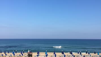 Una playa cerca, sillas reclinables de playa, toallas de playa