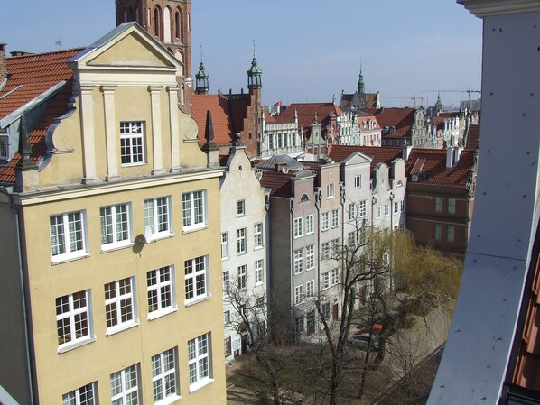 A row of traditional European buildings with uniform facades and red-tiled roofs.