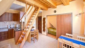 A compact kitchen with wooden cabinets, a built-in sink, and a staircase leading to a loft bedroom. - Comfortable apartment in the heart of Gdansk Old Town (Gdansk)