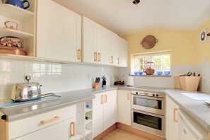 Enjoy cooking in this well-equipped kitchen with sleek cabinetry, a double oven, and toaster.