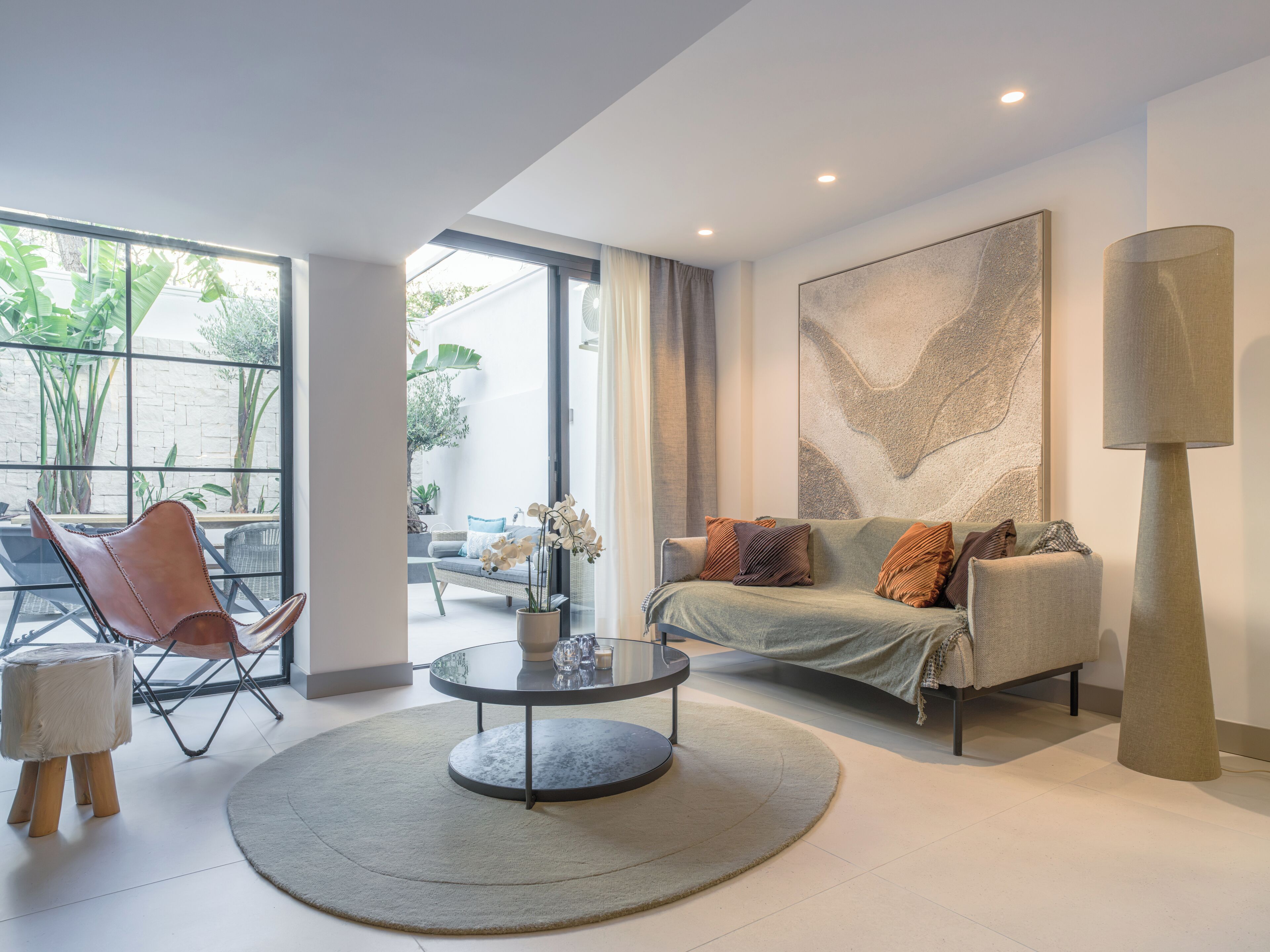 Un salon moderne avec un canapé, une table basse et une grande fenêtre.