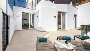 Eine moderne Außenpatio mit Holzmöbeln, einem Blumentopf und einem großen Sonnenschirm.