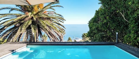 Una piscina con vista al mar y palmeras.