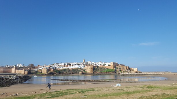 Un pueblo costero con edificios históricos, un río y una playa de arena.