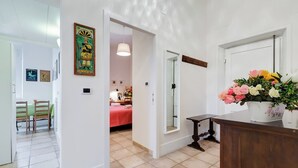 Eine Hotelhalle mit einer Rezeption, einem Spiegel und einer Blumenkomposition.