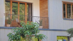 A modern two-story house with large windows and a balcony. - Sarlat La Caneda: SPACIOUS APARTMENT WITH GARDEN AND PRIVATE SWIMMING POOL (Sarlat-la-Canéda)