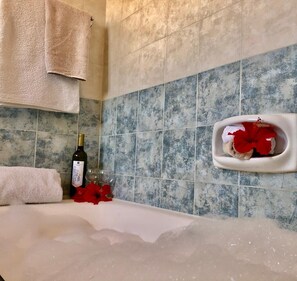 Bathtub, hair dryer, towels, toilet paper