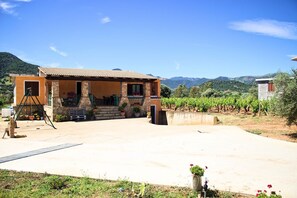 Um edifício com telhado telhado, fachada de pedra e entrada com calçada.