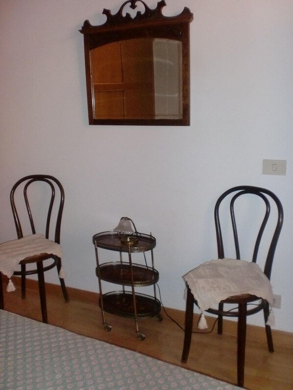 A room with two wooden chairs, a small table, and a wall-mounted mirror. - Rome: Romantic penthouse of 700 with wifi, fireplace and a panoramic terrace in the heart of the historic center, near Piazza Navona (Roma)