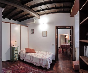 A bedroom with a bed, a dresser, a mirror, and a door leading to another room. - Rome: Romantic penthouse of 700 with wifi, fireplace and a panoramic terrace in the heart of the historic center, near Piazza Navona (Roma)