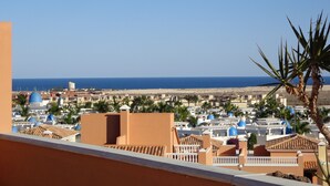 Ein Küstenort mit mehreren Gebäuden, darunter einige mit blauen Kuppeln, und freiem Blick auf das Meer.