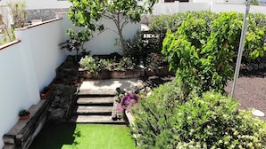 A garden with a wooden staircase leading to a small lawn area, surrounded by various plants and shrubs. - Lovely House - Pool/Garden/Wi-Fi - Casa Palmera (L'Escala)
