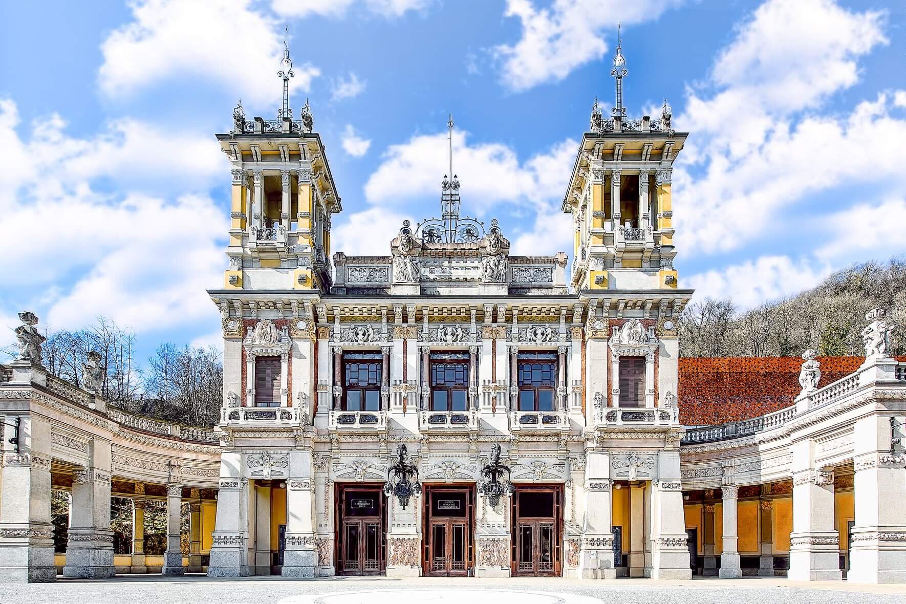 A grand, ornate building with two towers, large windows, and detailed architectural elements.