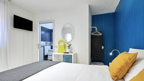 A modern hotel room with a bed, a desk, a mirror, and a TV. - Design seashell design (San Pellegrino terme bergamo)