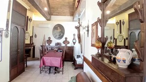 A cozy room with a wooden ceiling, a dining area with a table and chairs, a large mirror, and various decorative items.