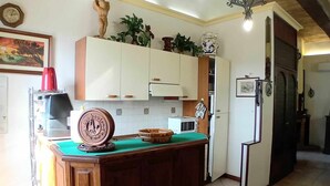 A kitchen with wooden cabinets, a central island, and a chandelier.