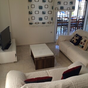 A living room with a white sofa, a wooden coffee table, and a TV on a stand. - Detached Villa - Private Pool - Stunning Mountain Views (12-2 Bn. B Dr. Fethiye)