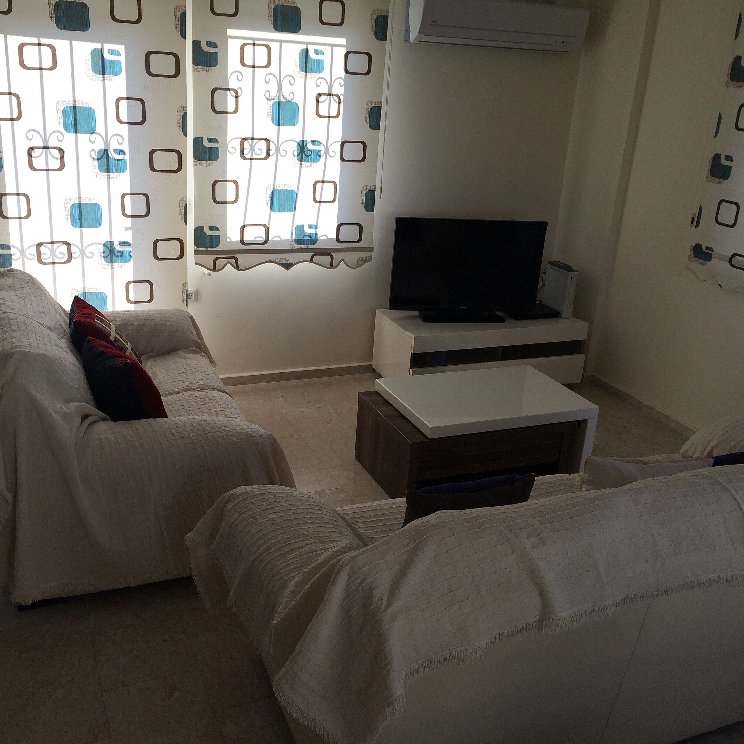 A living room with a sofa, a coffee table, and a television.
