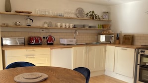 Una cocina moderna con armarios de madera, una mesa redonda y sillas azules.