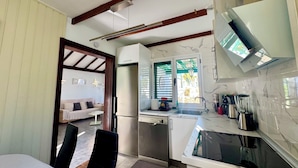 A compact kitchen with a built-in oven, a microwave, and a coffee maker. There is a dining area with a table and chairs.