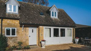 A two-story house with a stone facade, a large garage door, and a small attached shed. - Boutique cottage in a quiet corner of Chipping Campden, a Cotswold gem. (Chipping Campden)