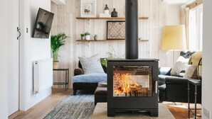 A modern living room with a wood-burning stove, a sofa, a coffee table, and a lamp. - Boutique cottage in a quiet corner of Chipping Campden, a Cotswold gem. (Chipping Campden)