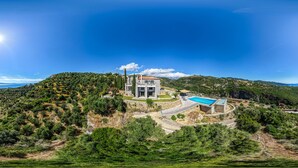 A modern house with a swimming pool, surrounded by hills and greenery. - Private infinity pool & hot tub. Breathtaking sea & mountain views. (Kalamata)