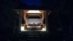 Una cabaña acogedora y luminosa con una cama, un muro de piedra y techo de madera.