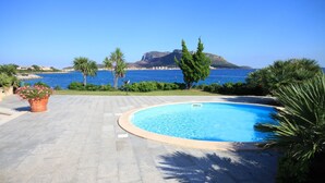 A swimming pool with a clear view of the sea and a mountain in the background. - Villaggio S'abba e Sa Pedra - S'ABBA DI SU (Golfo Aranci)