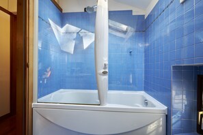 Een bad/douchecombinatie, een haardroger, een bidet, handdoeken