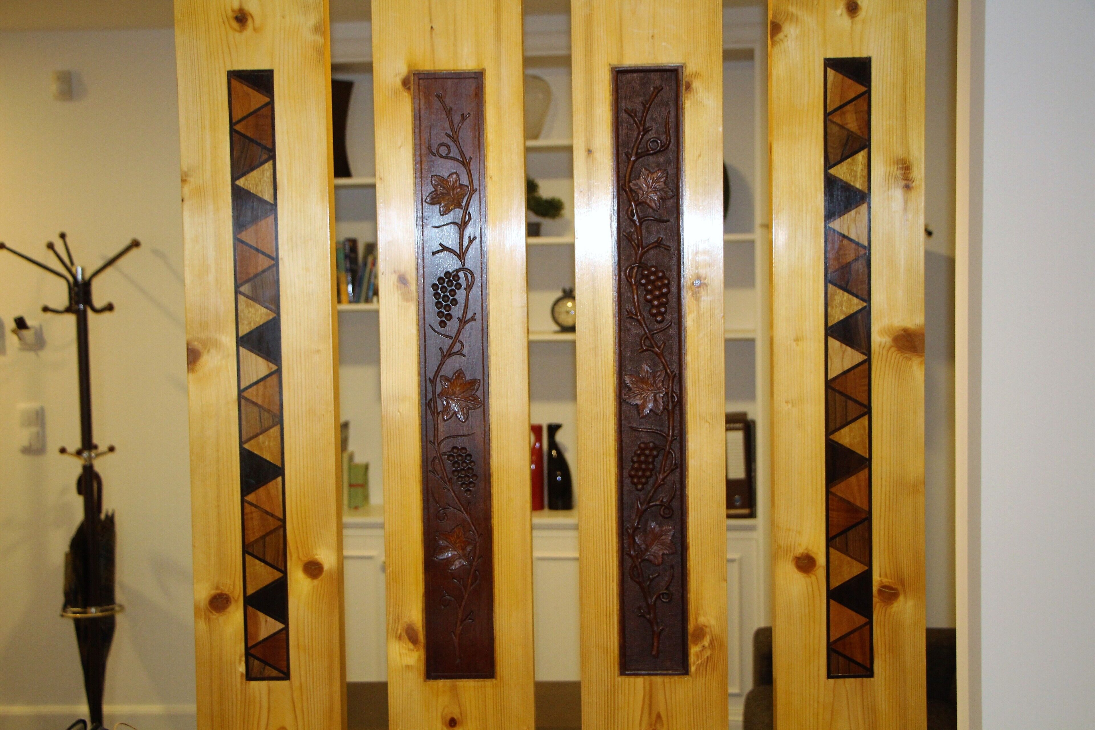 Un panel de madera con elaboradas tallas de uvas y hojas.