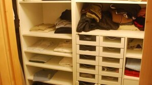 Um armário com prateleiras para roupas dobradas, gavetas para sapatos e espaço para itens pendurados.