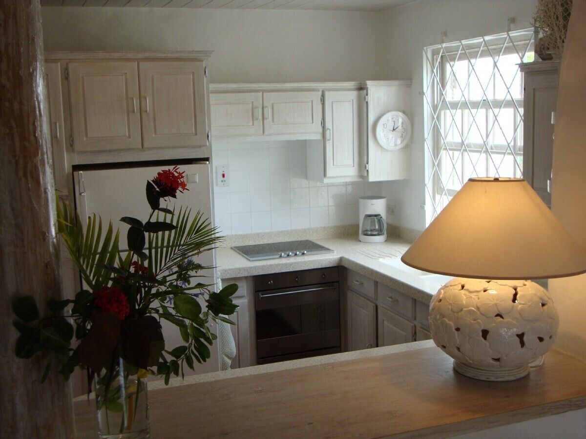 A kitchen with white cabinets, a coffee maker, and a lamp on the counter.
