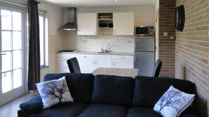 Una cocina moderna con armarios blancos, un microondas y un refrigerador.