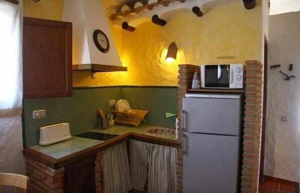 Una cocina compacta equipada con microondas, tostadora y refrigerador.