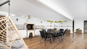 A modern kitchen with a built-in oven and a dining area with a table and chairs.