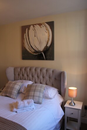 A neatly made bed with a headboard, a bedside lamp, and a painting on the wall. - Fab Townhouse Within Bar Walls, short Walk to River & City. Parking for 2 cars.  (YORK)