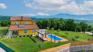 A yellow villa with a swimming pool, surrounded by lush greenery and mountains in the background. - New Villa for 8 people with spectacular view (Potpican)