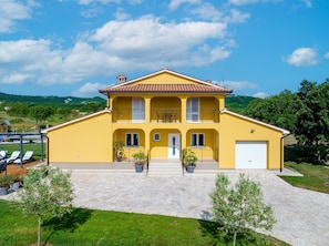 A two-story yellow house with a tiled roof, a front porch, and a garage. - New Villa for 8 people with spectacular view (Potpican)