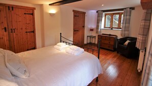 Un dormitorio con una cama grande, un armario de madera y una ventana con cortinas.