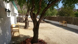 A tree-lined outdoor area with benches, a lamp post, and a white wall. - Beautiful home in paradise three minutes from the best virgin beaches (Nijar)