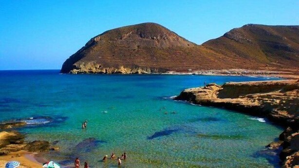A coastal landscape with clear turquoise waters, rocky terrain, and a mountain in the background. - Beautiful home in paradise three minutes from the best virgin beaches (Nijar)