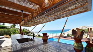 A poolside area with a view of the ocean, a bar area with a sink, and two decorative vases. - Exclusive villa on the beach front. FREE WIFI (Tarifa)