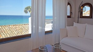 A room with a white sofa, a table with two glass jars, and a view of the sea through large windows with white curtains. - Exclusive villa on the beach front. FREE WIFI (Tarifa)