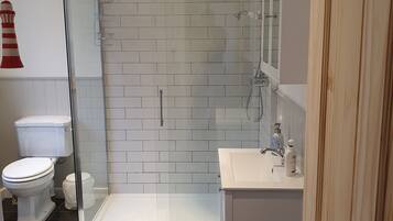 Bathtub, hair dryer, towels, toilet paper