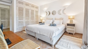 A bedroom with a bed, bedside tables, a wardrobe, and a seating area. - Villa Dome OCV - Private Heated Pool (Albufeira)