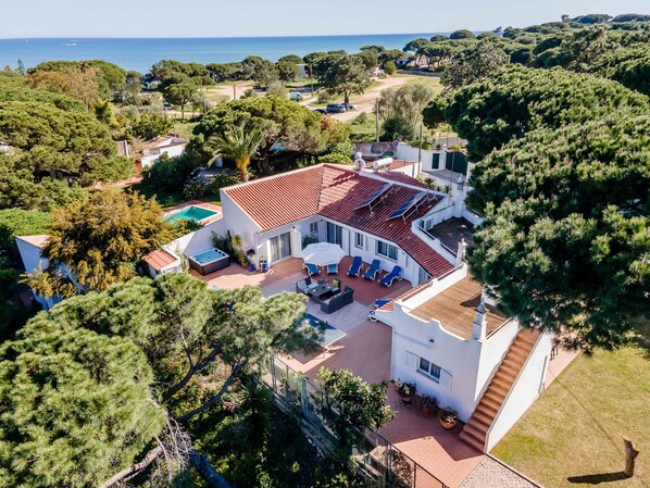 A large house with a swimming pool, outdoor seating area, and a view of the sea. - Luxury Villa, Private Large Jacuzzi,100 Metres From Santa Eulalia Beach (Albufeira)