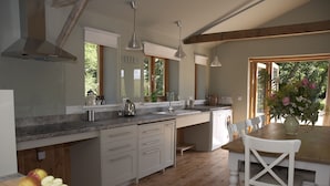 Una cucina moderna con una grande isola, pavimento in legno e vista sull'esterno.