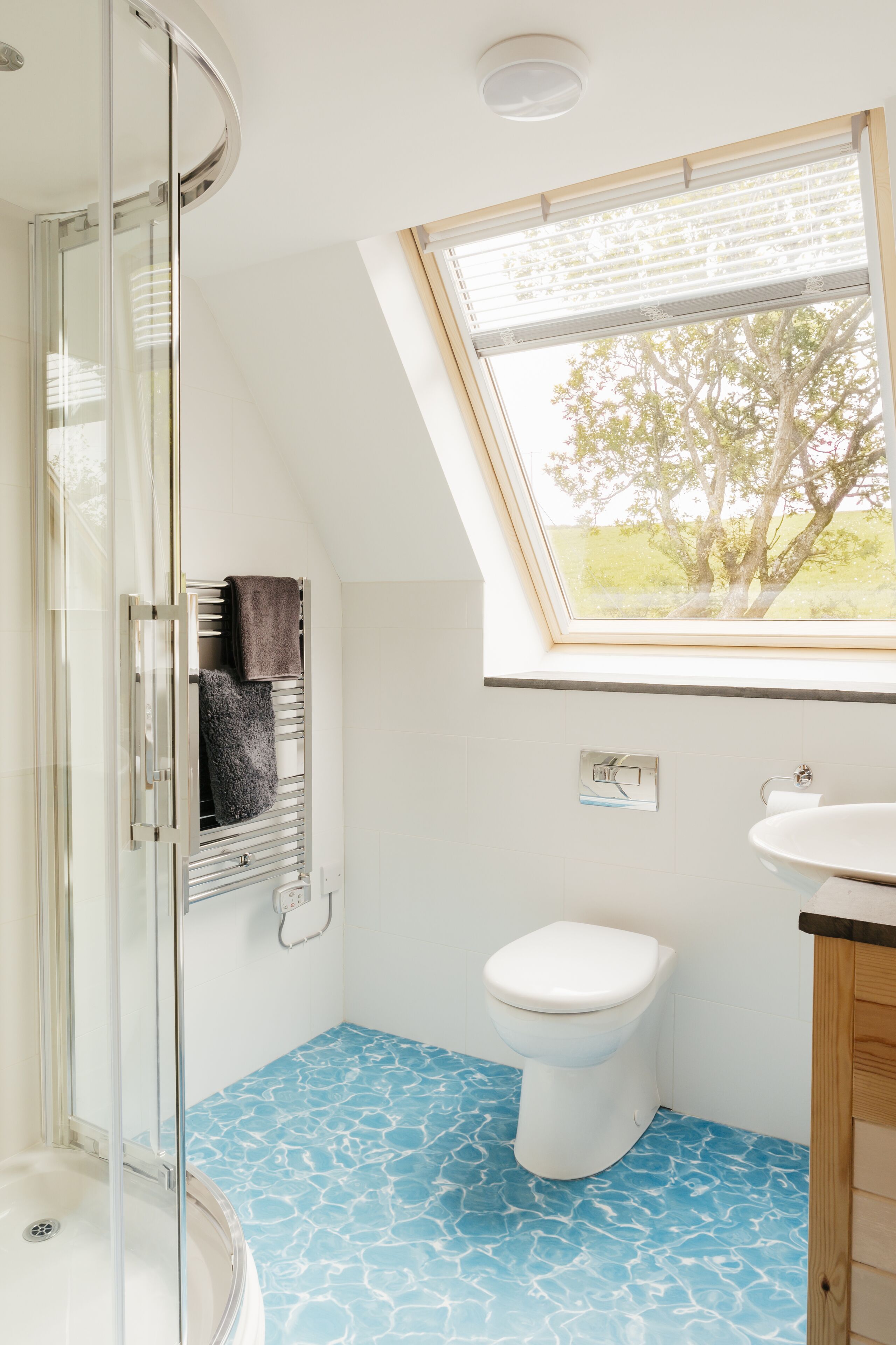 A bathroom with a glass shower enclosure, a white toilet, and a sink.