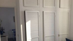 Une chambre à coucher avec un lit, une chaise et une armoire à volets.